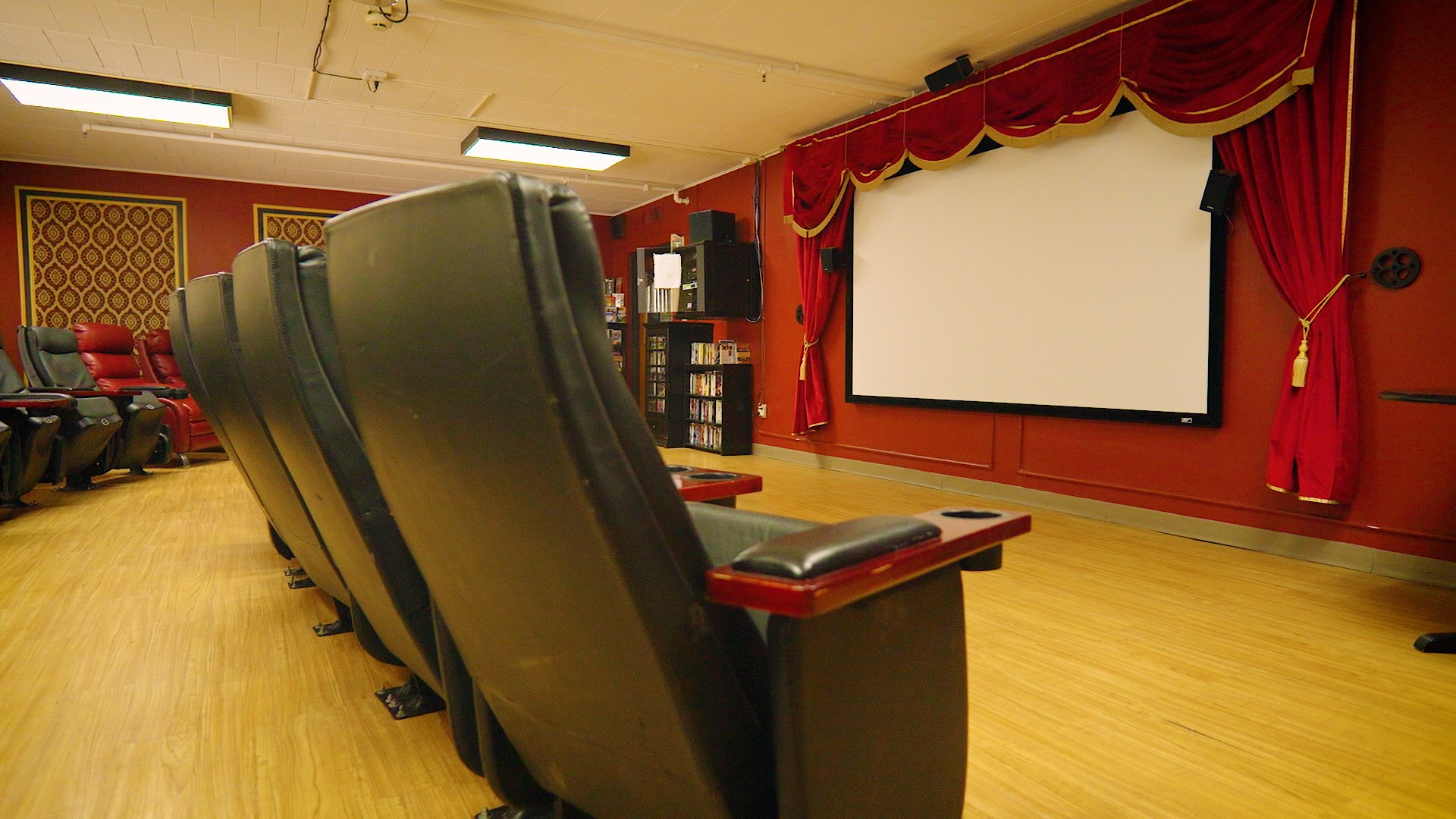 Cedar Woods assisted living movie theater seating and large cinema screen in Belleville, Michigan