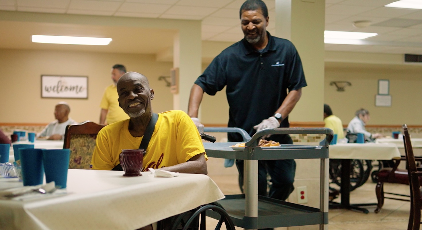 Smiling resident enjoying assisted living dining at Cedar Woods in Belleville MI