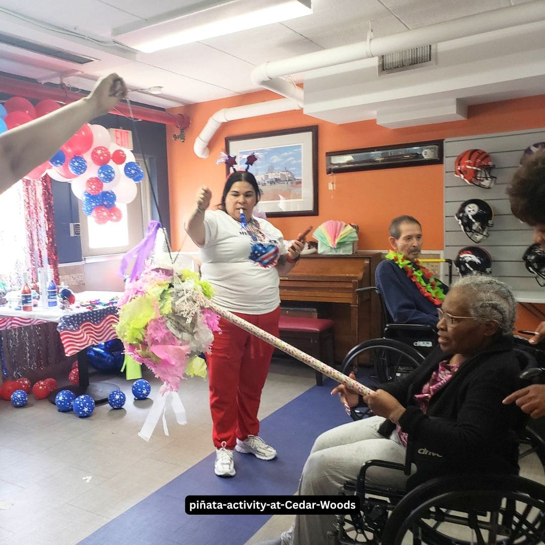Residents participating in a pinata activity at Cedar Woods