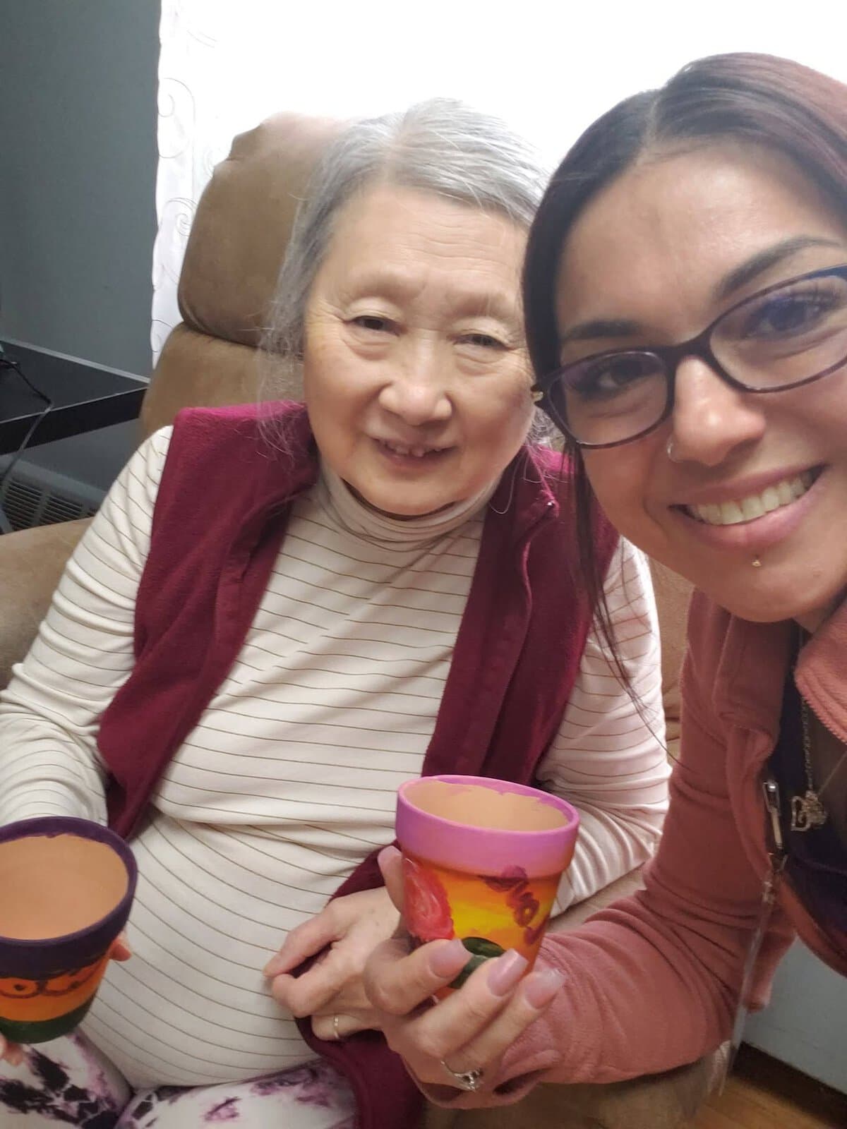 Cedar Woods team member sharing a meaningful activity with a memory care resident in Belleville, Michigan