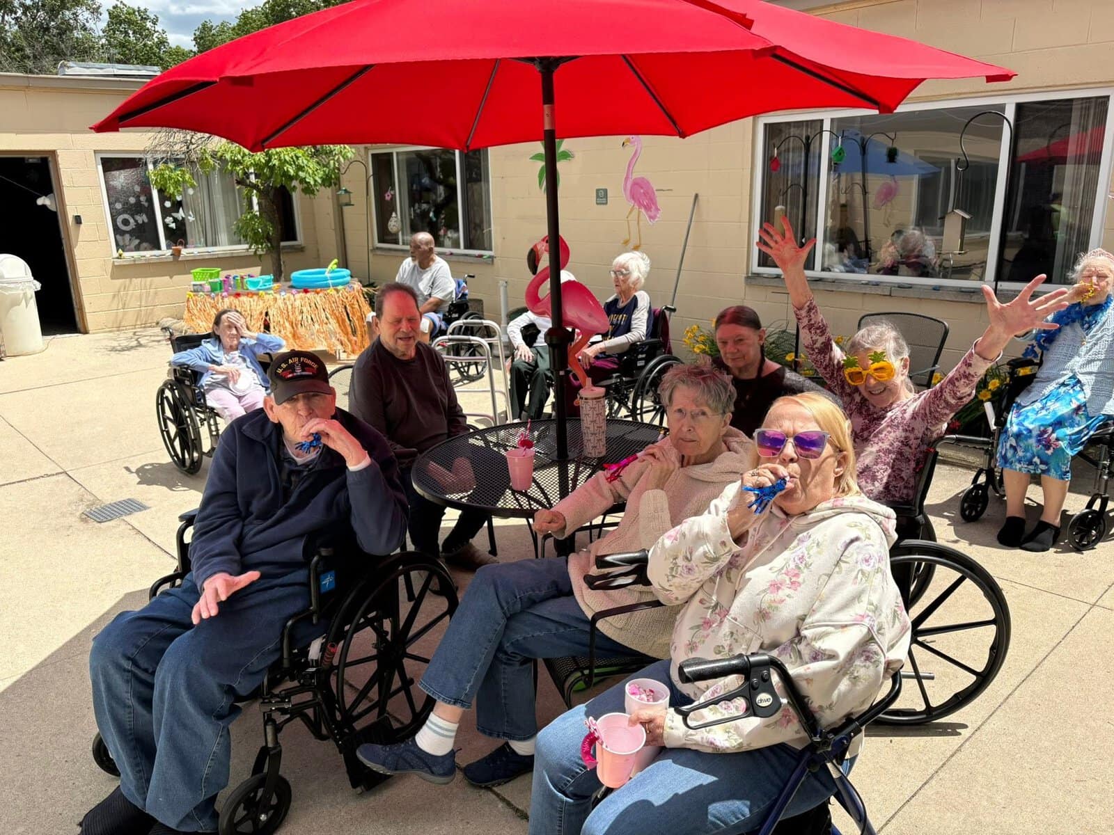 Residents enjoying an outdoor tropical-themed community gathering at Cedar Woods Assisted Living and Memory Care in Belleville, Michigan